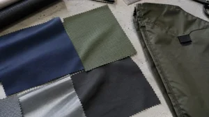 Different nylon fabric swatches and an unbranded bag panel on a textile development table